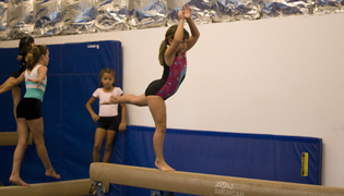Girl doing a cratwheel on Beam